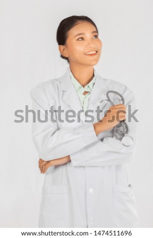 closeup portrait on Asian medicine doctor woman holding stethoscope and smile teeth isolated white background.