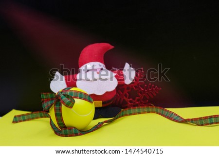 Tennis ball and Santa Claus for Christmas Holiday on black background