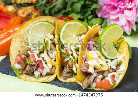 Tacos crowned with lime surrounded by flowers close up