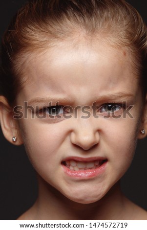 Close up portrait of little and emotional caucasian girl. Highly detail photoshot of female model with well-kept skin and bright facial expression. Concept of human emotions. Angry, agressive.