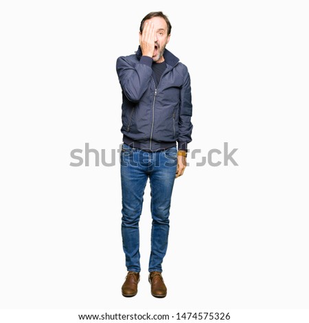 Middle age handsome man wearing a jacket Yawning tired covering half face, eye and mouth with hand. Face hurts in pain.