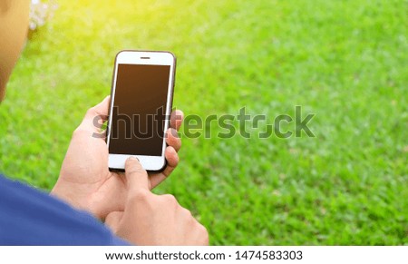 Men are using mobile phones with blank screens in the park.