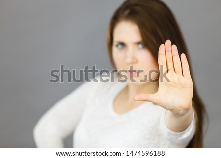 Angry apodicticity woman showing stop sign gesture with open hand, denying something,