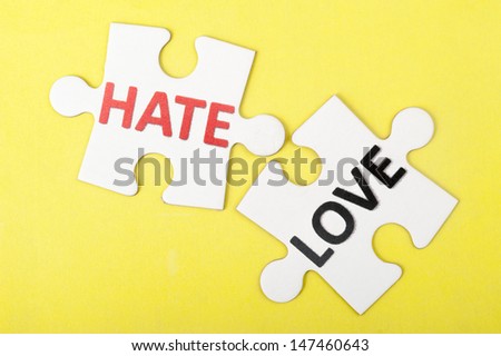 Hate versus love concept words on two pieces of jigsaw puzzle