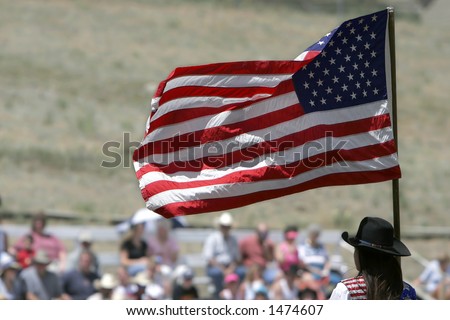 Presenting the colors (American Flag) to a rodeo crowd before the start of action (shallow focus).