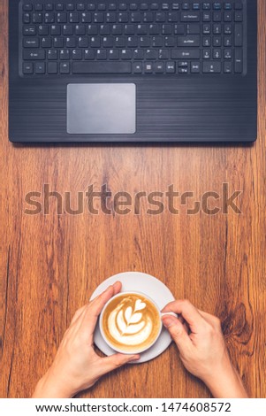 male freelancer enjoy coffee and online working on laptop computer. top view