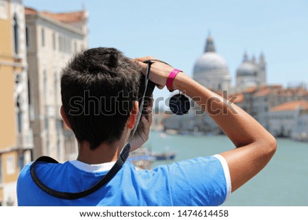 boy potographs the famous Basilica of Saint Mary of Health in Venice