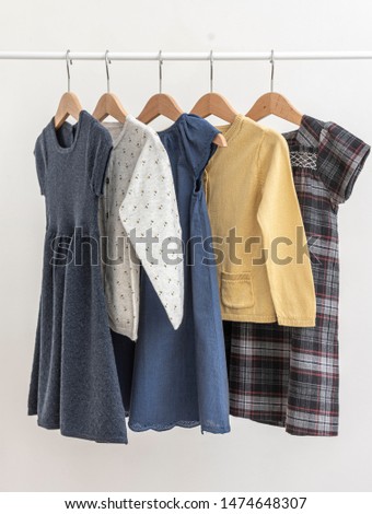 Dresses and  cardigans (jackets) for girl hanging on sholders on a white background/ Summer wardrobe / Children's clothes Royalty-Free Stock Photo #1474648307