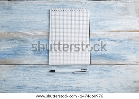 notebook with pen or pencil on a blue and white shabby vintage wooden background. the view from the top. Flat lay
