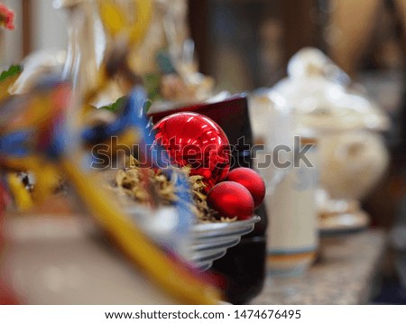 Flea market, interior. Blurred background, in the center of the picture a red ball for Christmas tree.