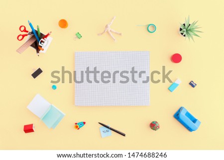 Blank file cover and school stationery around on a yellow table. Top view. Creative flat lay. Back to school.
