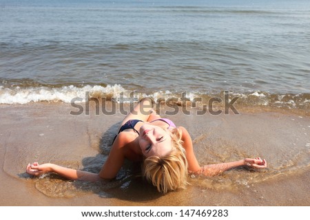 Beautiful woman in bikini sunbathing at the seaside blue sky