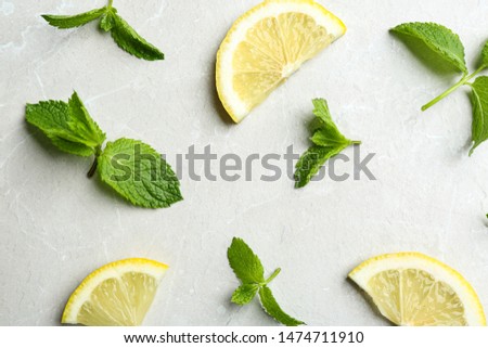 Fresh mint with sliced lemon on grey marble background, flat lay