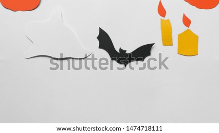 Halloween decorations with paper pumpkins, bats, candles and ghosts on white background. Halloween and decoration concept. Flat lay, top view, copy space