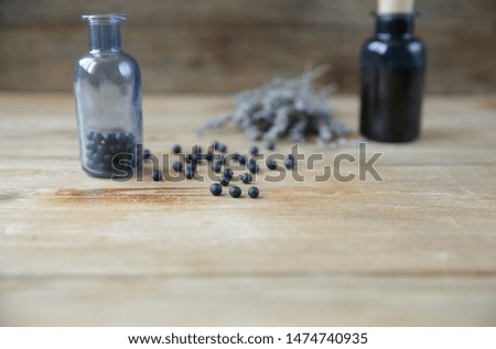 Homeopathic balls in a glass bottle and essential oil in a bottle and lavender herb on a wooden background Alternative medicine Herbal homeopathy. Healthcare Aromatherapy With copy space for text.