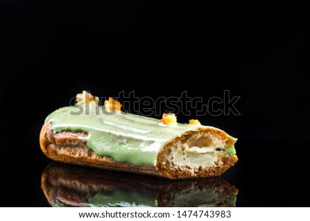 French Artisan Eclair on Black Reflective Background,Copy Space. Patisserie Bakery Product.