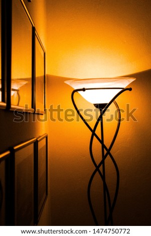 A lamp near a wall full of pictures