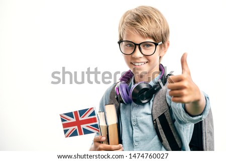 Smiling english schoolboy shows thumbs up Royalty-Free Stock Photo #1474760027