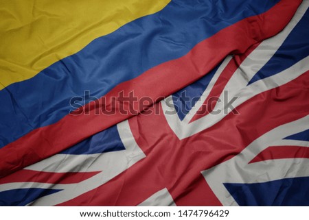 waving colorful flag of great britain and national flag of colombia. macro