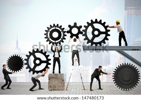 Teamwork works together to build a gear system Royalty-Free Stock Photo #147480173