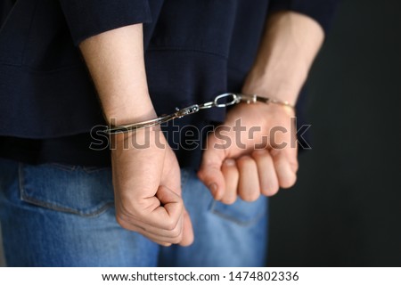 Man detained in handcuffs indoors, closeup view. Criminal law Royalty-Free Stock Photo #1474802336