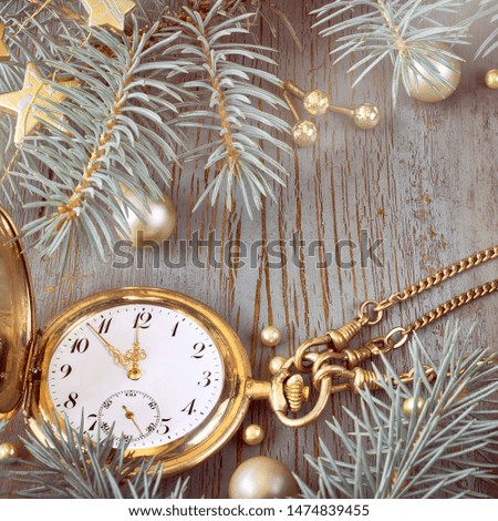 Vintage pocket watch showing five to twelve on gray rustic background with Christmas twigs and golden decorations, space for your text