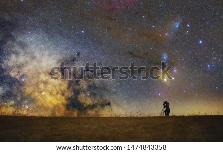 Astrophotographer shooting milky way scene full of stars and nebulas Royalty-Free Stock Photo #1474843358