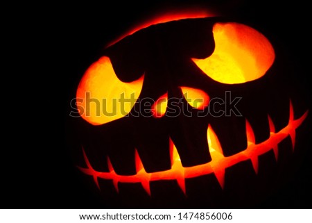 Ghastly Halloween pumpkin head jack lantern on black background