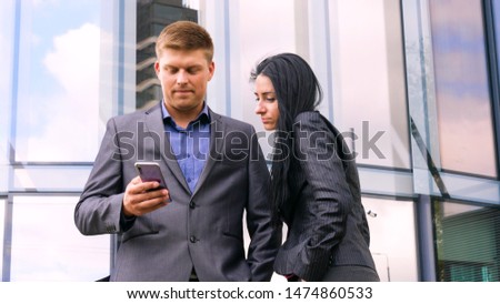 Fun Young Couple Taking Selfie With Mobile Phone on skyscraper background. Concept of: Suite, Business, Couple, Architecture, Smartphone, Lifestyle, 5g network.