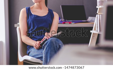 Young woman sitting on the desk in office
