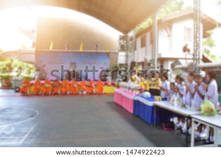 Blurred images about making merit, giving alms and praying in Buddhism for teachers and students in Thai schools.