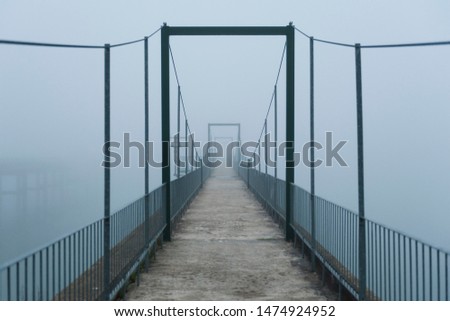 Suspension bridge in the early morning fog