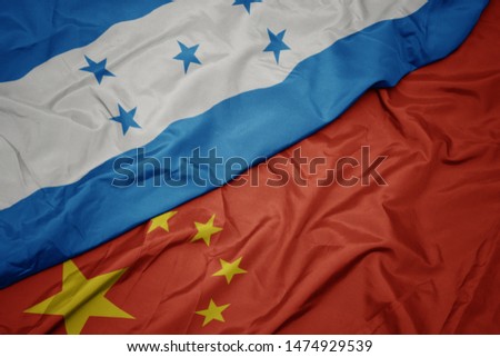 waving colorful flag of china and national flag of honduras. macro