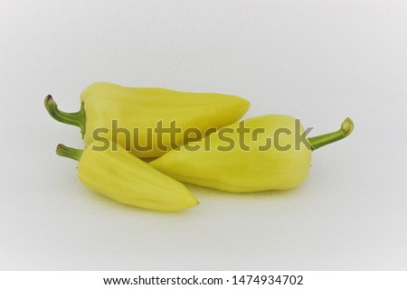 Fresh green peppers against white background. Green and yellow peppers created a composition on a white background.