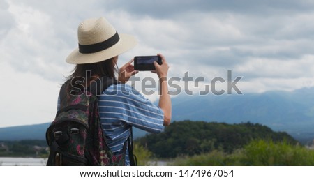 Woman take photo on cellphone when hiking
