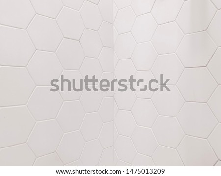 real photo of joint white hexagonal tiles wall in corner of the bathroom