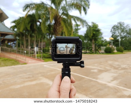 The photographer's hand is holding a video camera to take a view in one place.
