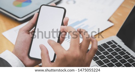 Close-up view of young businessman searching for idea in blank screen smartphone 
