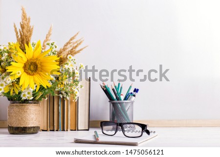 Teacher's day holiday greeting icon. Education knowledge day concept. Wooden chalk board frame and vase bouquet on table empty copy space.