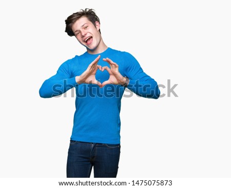 Young handsome man wearing blue sweater over isolated background smiling in love showing heart symbol and shape with hands. Romantic concept.