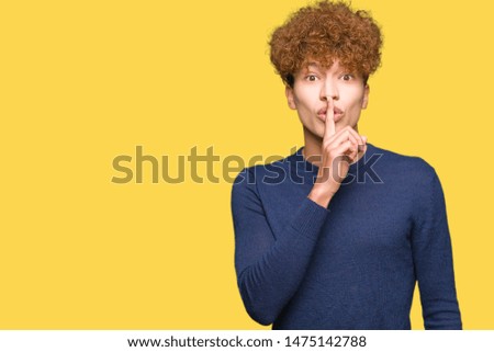 Young handsome man with afro hair asking to be quiet with finger on lips. Silence and secret concept.