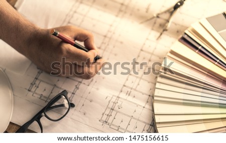 Architect & Engineer working drawing document about project planning and progress of work schedule on the home building construction site