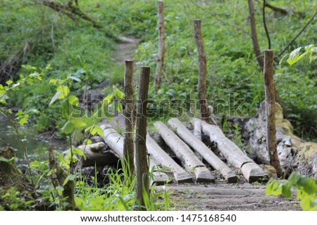 A bridge of wooden bars over a stream