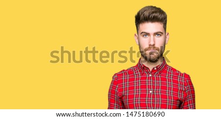 Young handsome man with serious expression on face. Simple and natural looking at the camera.
