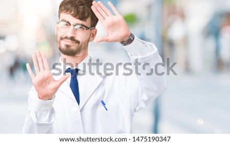 Young professional scientist man wearing white coat over isolated background Smiling doing frame using hands palms and fingers, camera perspective