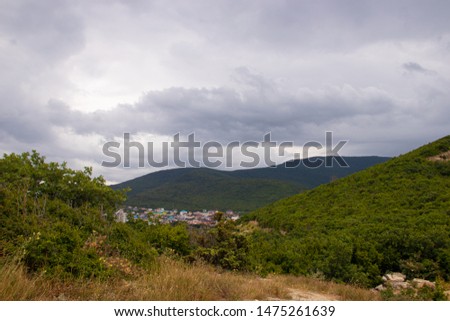 Southern highlands. Field with low mountains. Low mountains with trees. Anapsky district, Russia. Summer mountain landscape