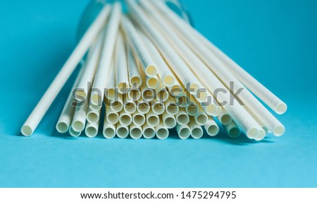 White paper straws against blue background  Royalty-Free Stock Photo #1475294795
