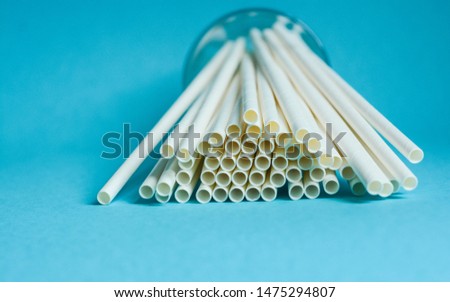 White paper straws against blue background  Royalty-Free Stock Photo #1475294807