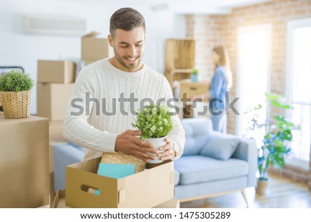 Young couple moving to a new home, handsome man smiling moving cardboard box