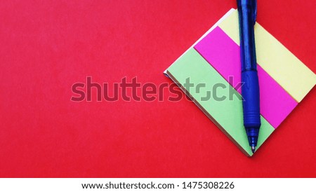 stick pad and pen isolated on red background with text space